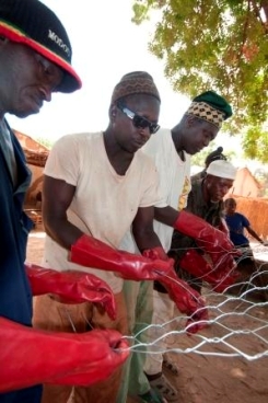 A group of men and women work together to build a wall to protect land from wind and water erosion in the village of Kaymor in Senegal. Photo: WFP/Jenny Matthews