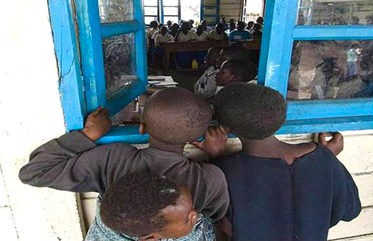 Children look through a window in a school