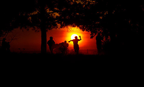 Children Sihuetted in front of a sun-set.