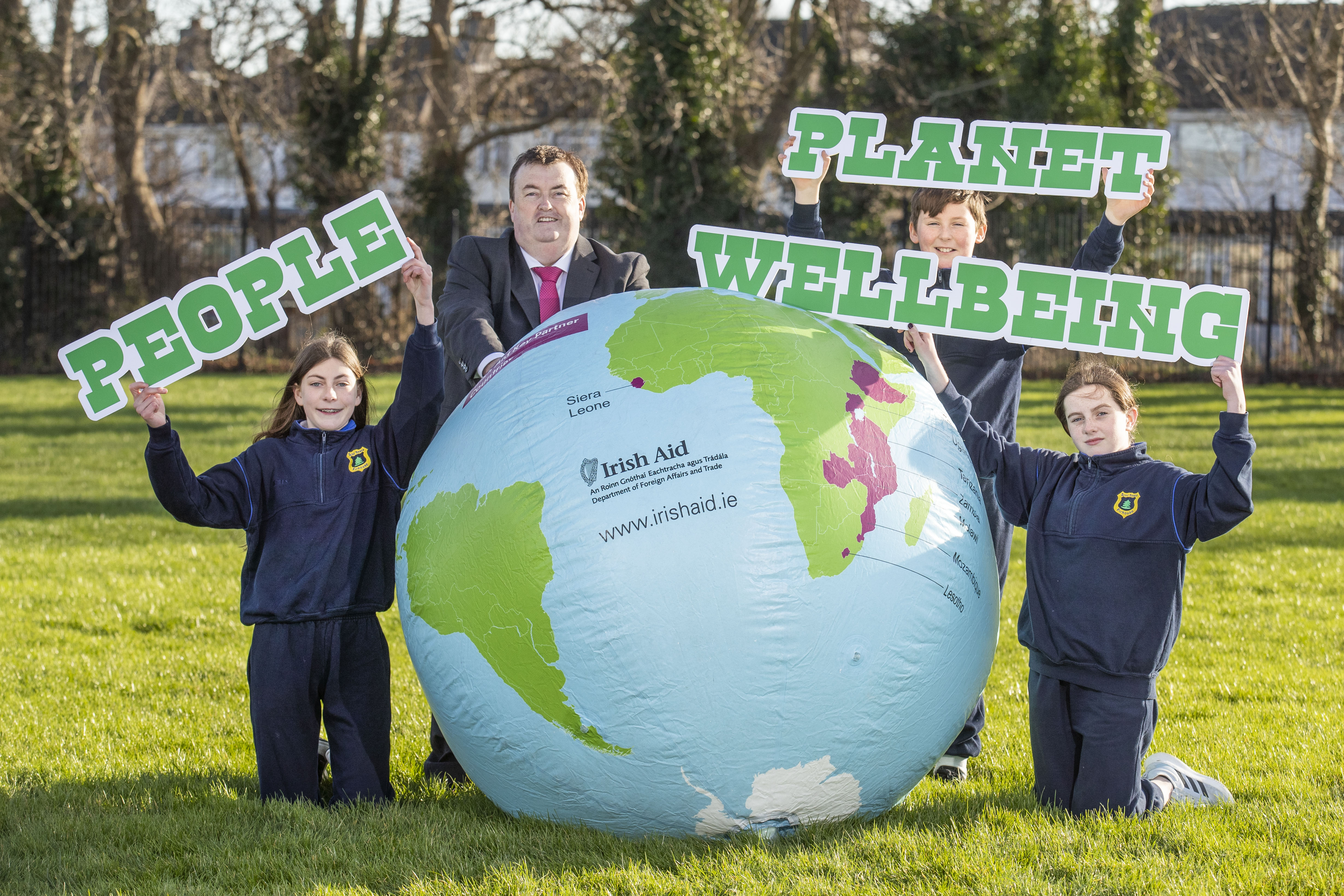 Minister Brophy with primary school pupils and image of globe 